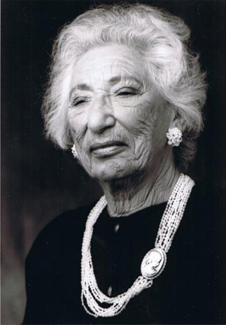 Black and white portrait of Raye Freedman, smiling, wearing a cameo necklace