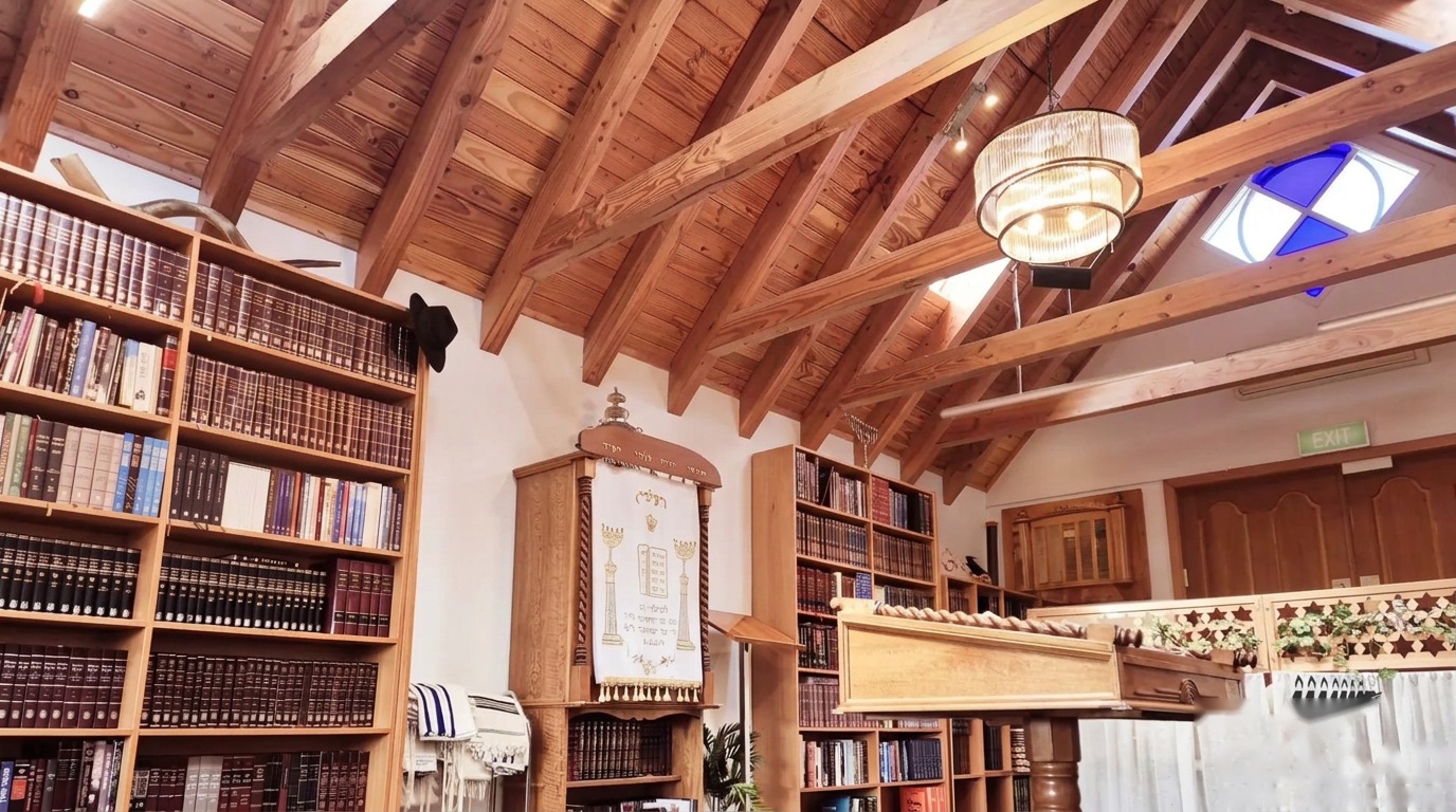 The interior of the Raye Freedman Library: timber cathedral ceiling, floor-to-ceiling bookshelves, the ark and the bimah