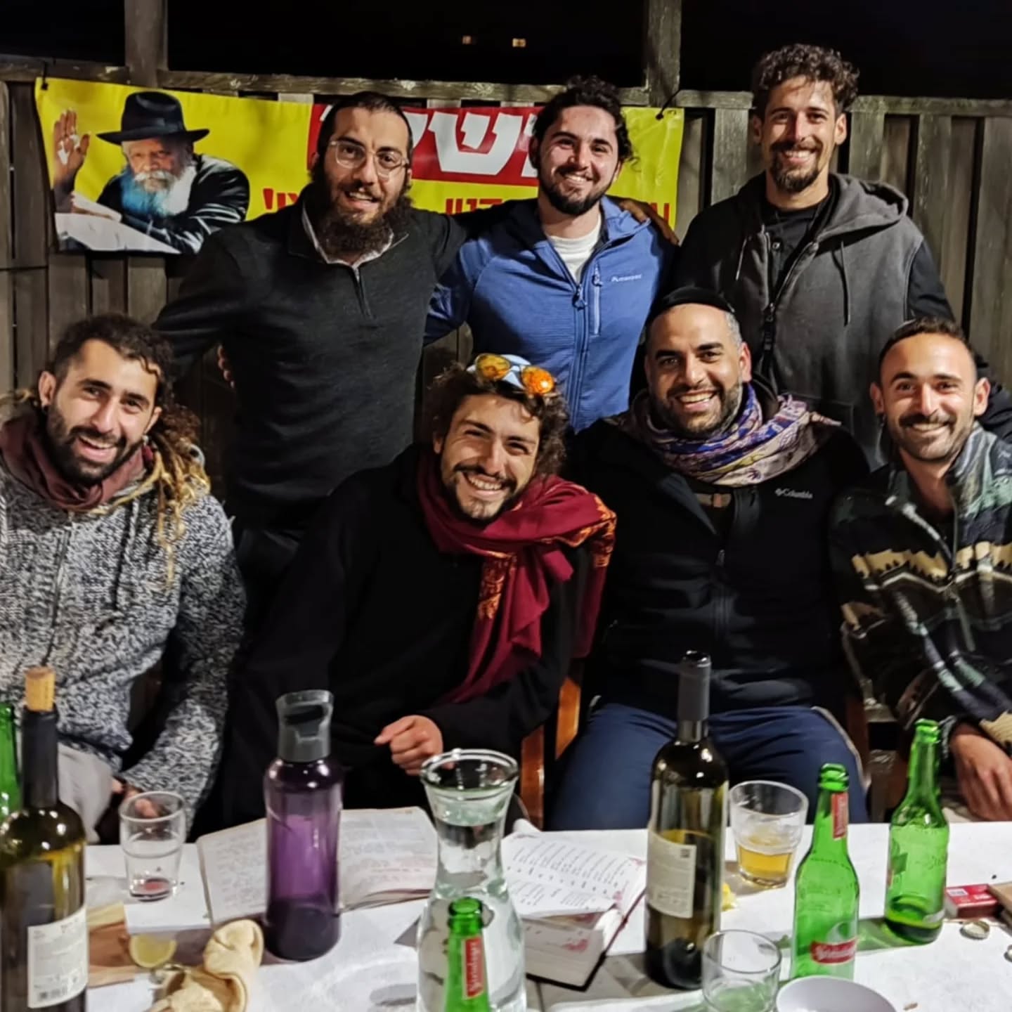 A group of young travellers gathered around a Shabbat table at 788